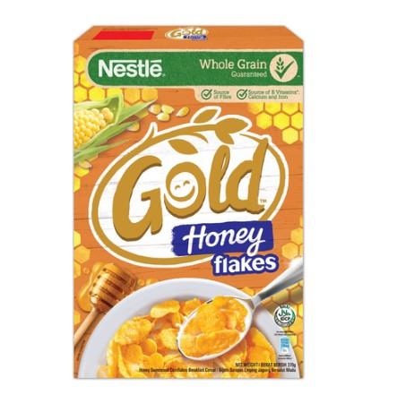 Box of Nestle Gold Honey Flakes cereal with corn and honey elements on a white background